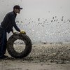 First prize winning photo portrays a volunteer removing a tire from a beach in Lima, Peru, taken by Nicolas Monteverde Bustamante of Universidad Peruana de Ciencias Aplicadas, Lima, Peru.