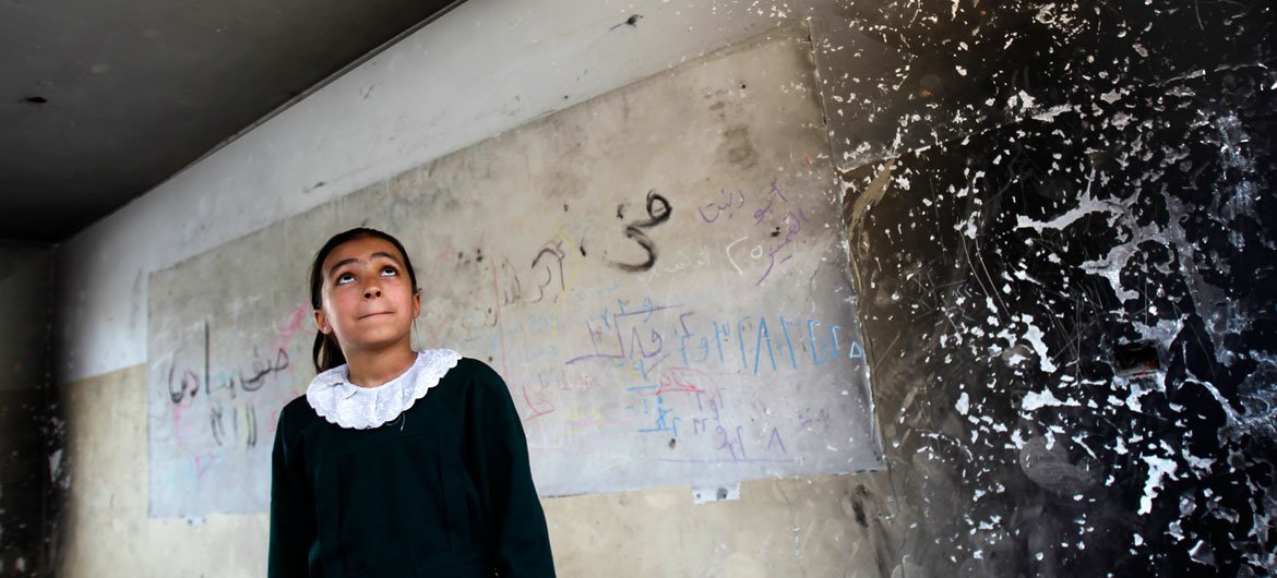 On 20 April 2016 in Gaza, Occupied Palestinian Territories, a student looks inside of one of the classrooms that was destroyed during the 2014 hostilities.
