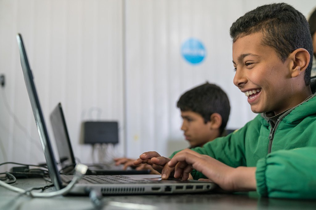 Un enfant de 11 ans utilise un ordinateur portable dans un camp de réfugiés syriens en Jordanie.