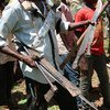 A commander of the anti-Balaka militia collects weapons handed in by children released by the group during a release ceremony in in Bambari in the Central African Republic.