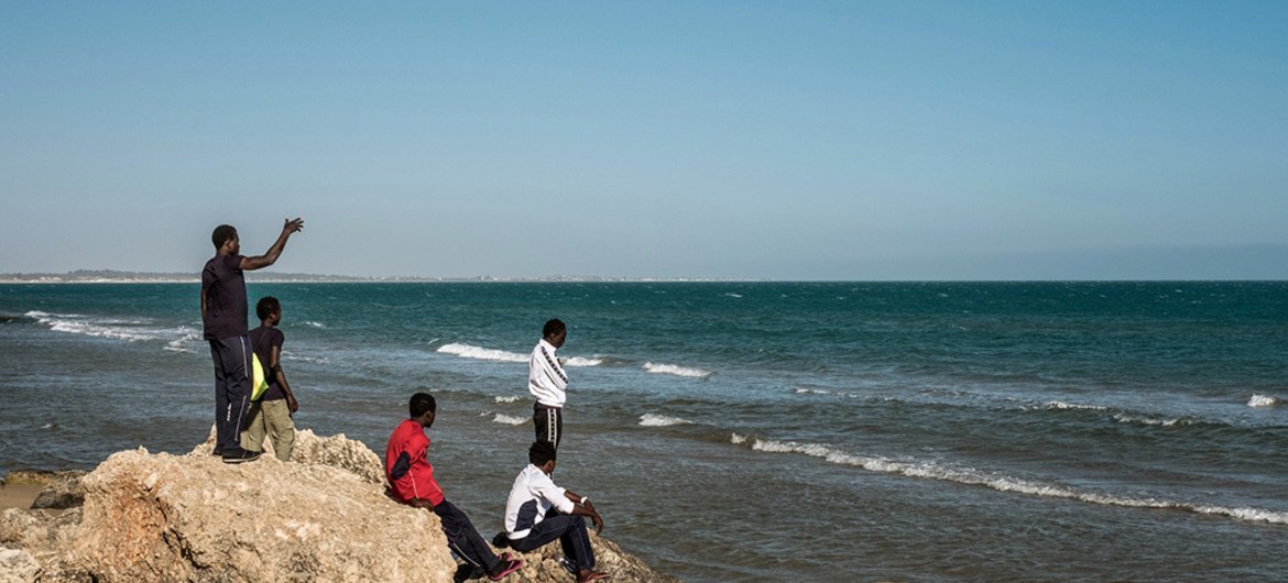 A group of Gambian boys survey the ocean from the beach during an outing from a government hot spot–a reception center that doubles as a lodging station for unaccompanied minors in Pozzallo, Sicily, on May 17, 2016.