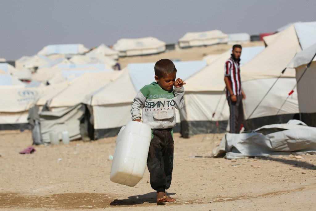 叙利亚东北部的阿尔霍尔营地，一名5岁男孩拿着水罐出门为全家人取水。