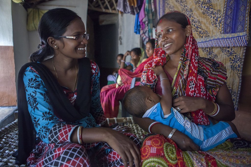 Sumi Madhi, una voluntaria para la lactancia, la nutrición y el cuidado de los niños, interactúa con una madre en Kudada, la India, donde hay 1250 hospitales acogedores.