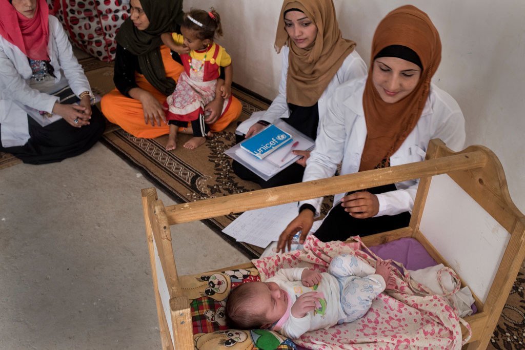 Health workers supported by UNICEF and the Directorate of Health visit a newborn and her mother in their shelter in Debaga displacement camp in Erbil Governorate, Kurdistan Region of Iraq (September 2016).