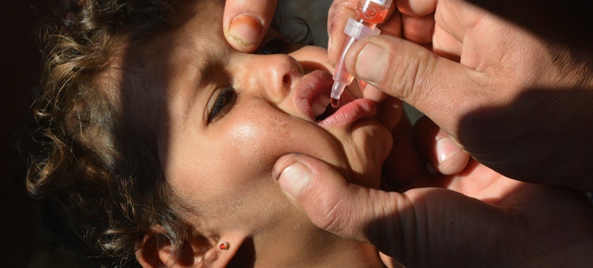 A health worker vaccinates a child against polio in Ghatno, central Syria, Homs.