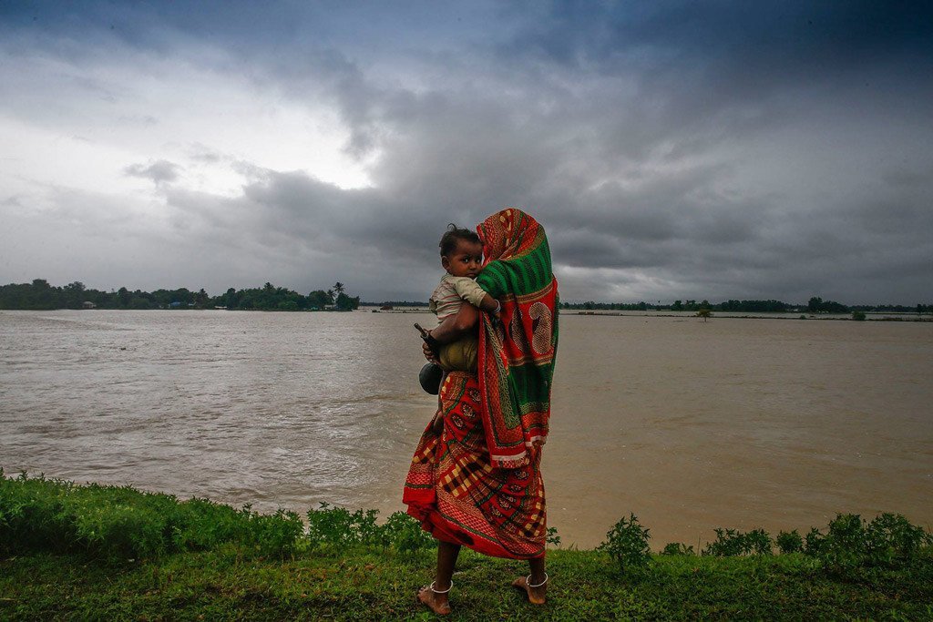 Displaced by the floods, a woman and her child walk along a road in southern Nepal.