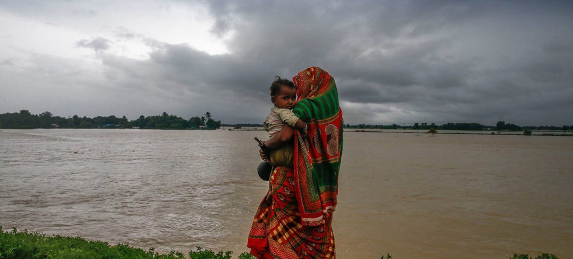 Déplacés par les inondations, une femme et son enfant marchent le long d'une route dans le sud du Népal.