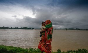 Displaced by the floods, a woman and her child walk along a road in southern Nepal.