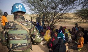 Un Casque bleu de la MINUSMA avec la population locale. Photo MINUSMA/Harandane Dicko
