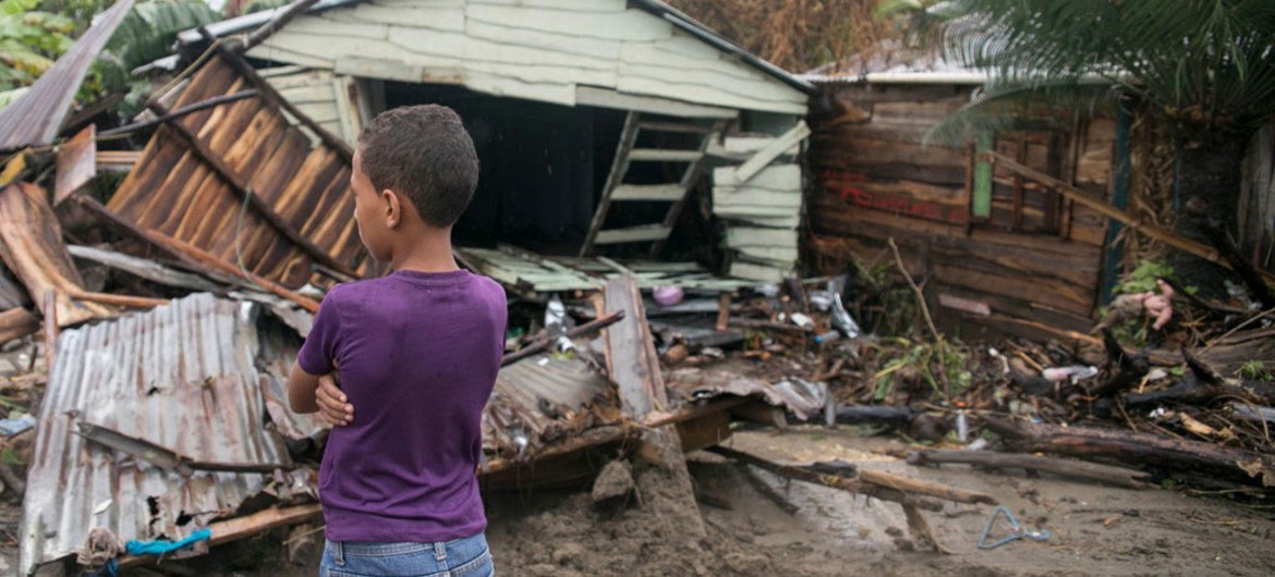 A seven-year old boy stands in front of debris as Hurricane Irma moves off from the northern coast of the Dominican Republic.