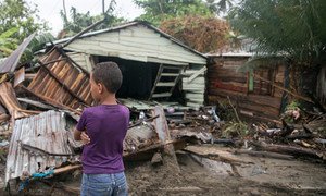 A seven-year old boy stands in front of debris as Hurricane Irma moves off from the northern coast of the Dominican Republic.