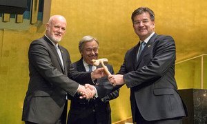 Peter Thomson (left), President of the seventy-first session of the General Assembly, passes the gavel on to Miroslav Lajcák (right), President of the seventy-second session, as Secretary-General António Guterres looks on.