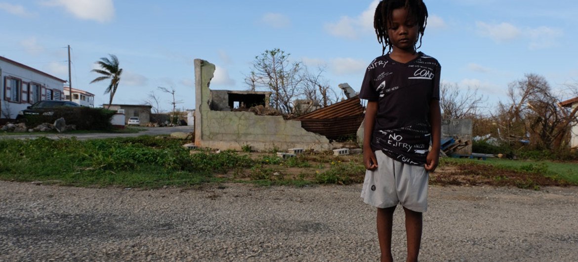 Un enfant de cinq ans devant des bâtiments partiellement détruits sur l'île d'Anguilla qui a été durement touchée par l'ouragan Irma. Septembre 2017.