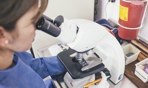Laboratory worker testing antibiotics on a resistant infection.