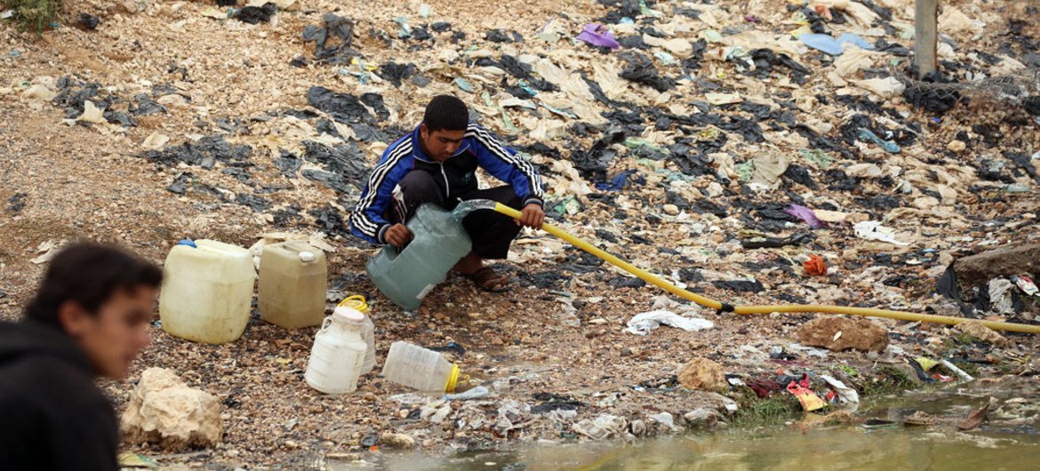 Boys in Al-Tabqa, the second largest city in Syria's Ar-Raqqa governorate, fill jerrycans with water.