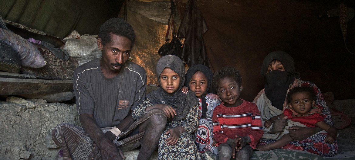 一个流离失所的家庭坐在也门喀米尔境内流离失所者定居点的帐篷里。