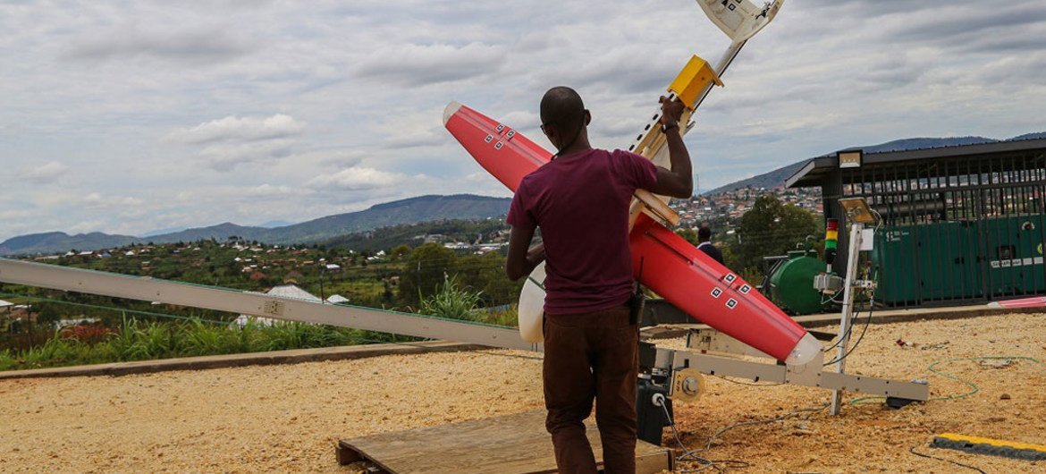 A man in Rwanda using a drone to deliver blood to a remote clinic.