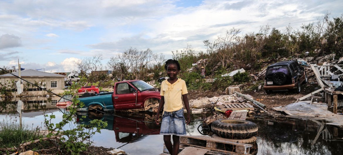Une fillette de sept ans traverse un pont de bois de fortune qu'elle a construit après que l'ouragan Irma ait causé de graves dommages sur le site de Five Cays, à Providenciales, dans les îles Turks et Caicos.