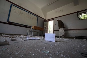 يمر أحد حراس المدرسة عبر مدرسة في العاصمة اليمنية صنعاء التي تضررت بشدة أثناء غارة جوية على المبنى المجاور لها.(الأرشيف)