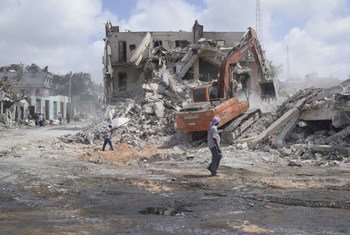 Remains of a building damaged by the bomb attack on Mogadishu being torn down by a digger.