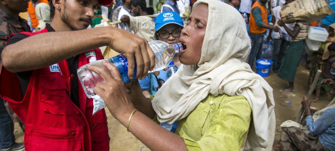 Le personnel du HCR et des volontaires partenaires aident les réfugiés rohingyas à leur arrivée dans un centre de transit près du village d'Anjuman Para, dans le district de Cox's Bazar, au sud-est du Bangladesh, après avoir été coincés pendant près de qu