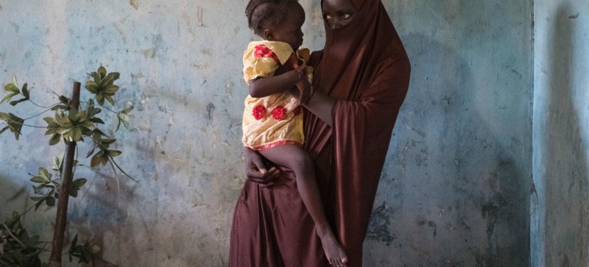 Dada, 15, holds her 18-month-old daughter Husseina where shes live in a host community in Maiduguri, Borno State, northeast Nigeria.