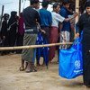 A woman collects hygiene kits for her family in Cox’s Bazar temporary settlement camps.