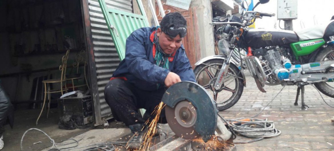 Hassan Hosseini working in a metal workshop that he partially owns, due to assistance from UN migration agency (IOM) offices in Greece and Afghanistan.