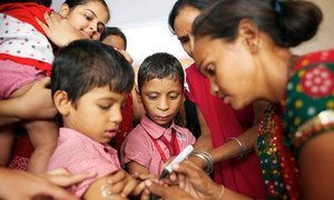 A health worker marks a boy’s finger with ink to show that he has been vaccinated against measles in India’s Gujarat State.