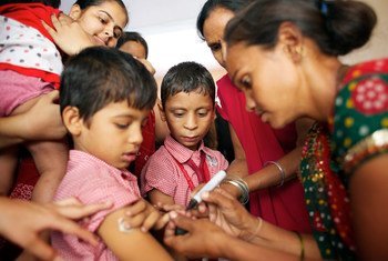 Une professionnelle de santé marque avec de l'encre le bras d'un garçon qui vient d'être vacciné contre la rougeole dans l'Etat du Gujarat, en Inde. Photo UNICEF/UNI133530/Pietrasik