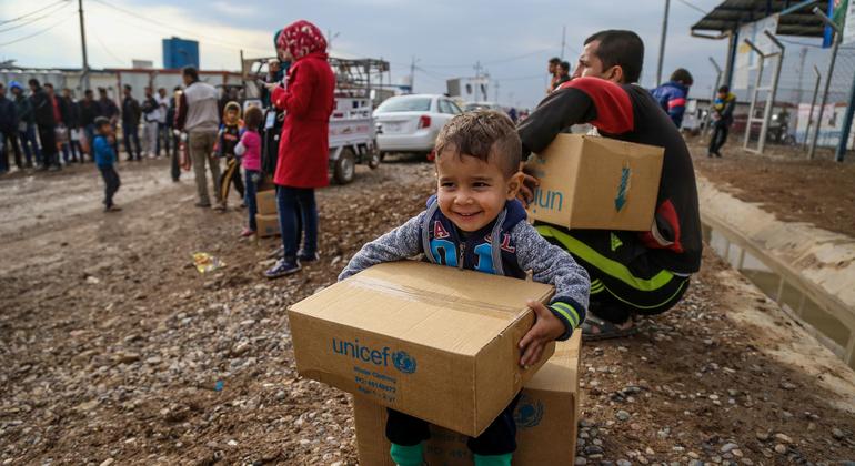 A three-year-old boy sits on a box of winter clothing that his family has received from a distribution at Kawergosk Syrian Refugee Camp in Erbil Governorate in the Kurdistan region of Iraq.