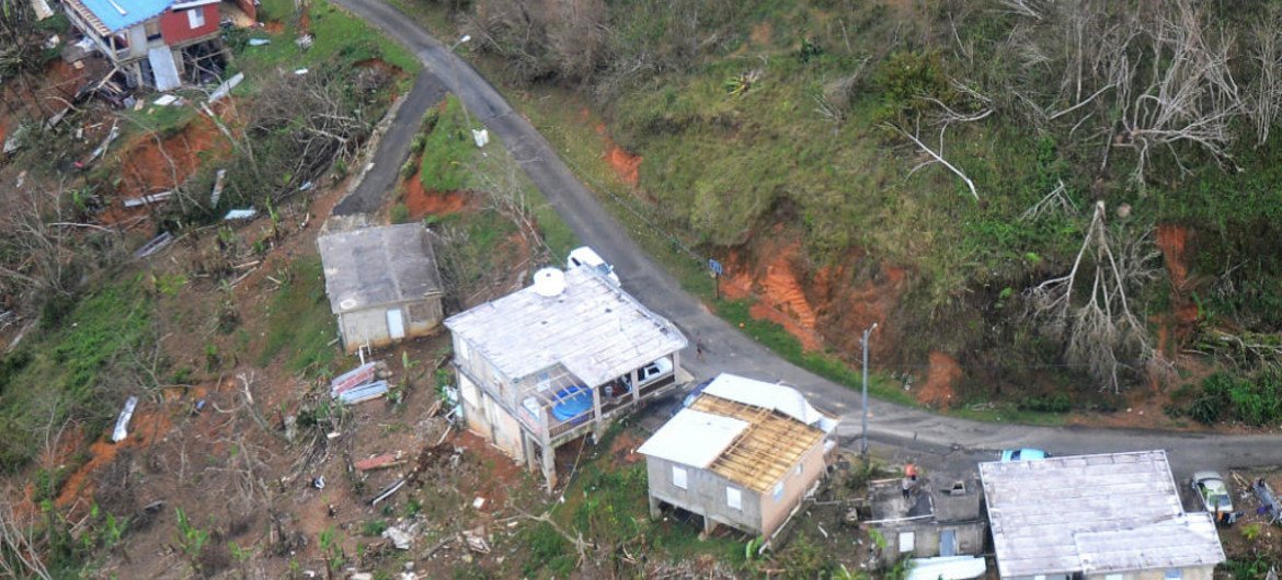 Residents wave from the roof of a house, bottom right, in Jayuya, Puerto Rico, 14 October 2017, to signal for help.