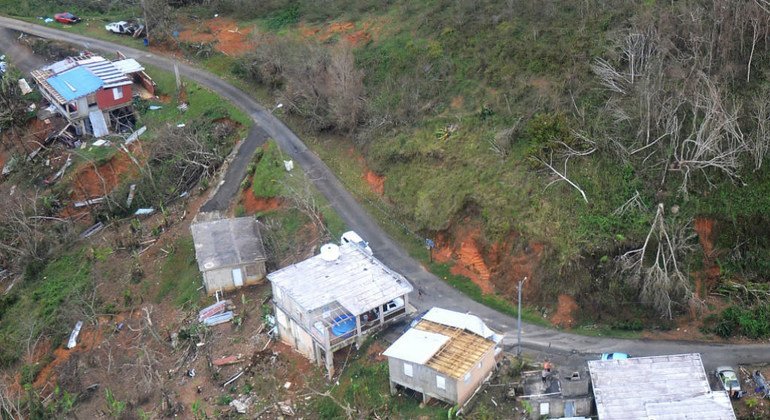Residentes piden auxilio desde el techo de una casa, abajo a la derecha, en Jayuya, Puerto Rico, luego del Huracán Maria en el 2017. 