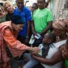 La Vice-Secrétaire générale de l'ONU, Amina Mohammed (à gauche) et l'Envoyée spéciale des Nations Unies pour Haïti, Josette Sheeran (à l'arrière plan gauche), avec des familles haïtiennes touchées par le choléra.