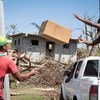 Men unload supplies from a pick-up truck in Salybia, one of the areas hit hard by Hurricane Maria in Dominica.