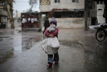 在大马士革古塔东区，一名儿童正拿着一带自己收集的柴火准备回家。
