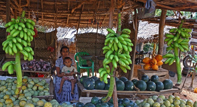 Uma mulher vende frutas e vegetais no Sri Lanka.