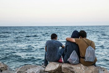 Migrants look out at the sea in Lesvos, Greece.
