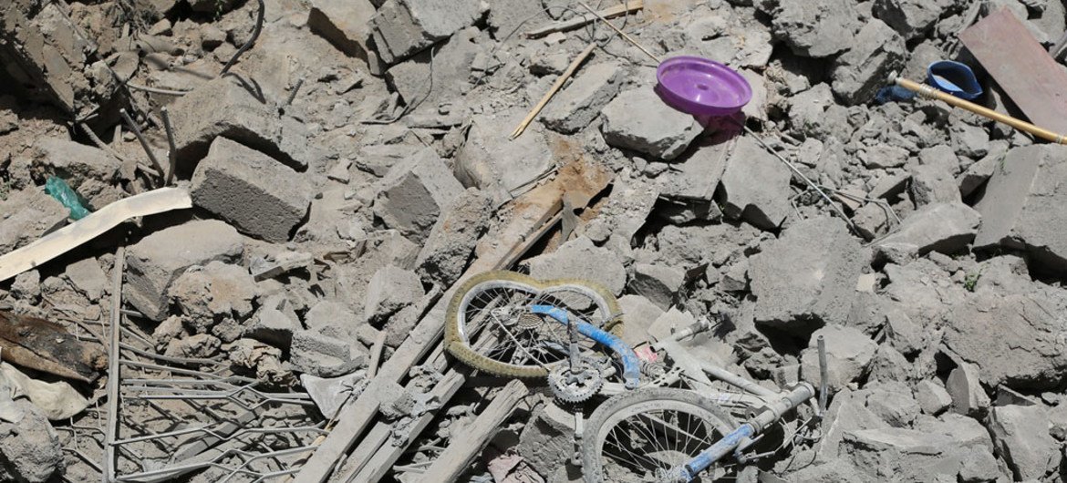 也门首都萨那，一个孩子的自行车被丢弃在房屋瓦砾上。（资料）。图片：OCHA/Charlotte Cans