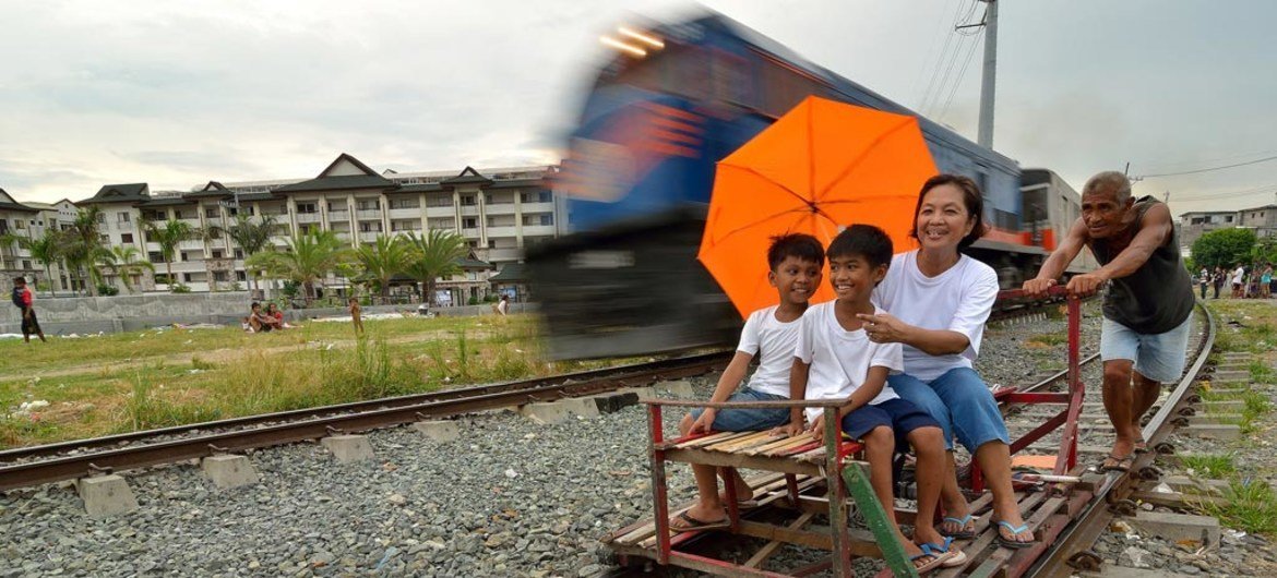 Un train passant un 'trolley', une charrette de fortune en bois, à Manille, aux Philippines. Photo ESCAP/Anthony Into