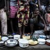 Des familles congolaises déplacées de la province du Kasai font la queue pour obtenir de la nourriture dans les locaux d'une ancienne clinique de ville d'Idiofa, après avoir fui la violence près de leurs villages.