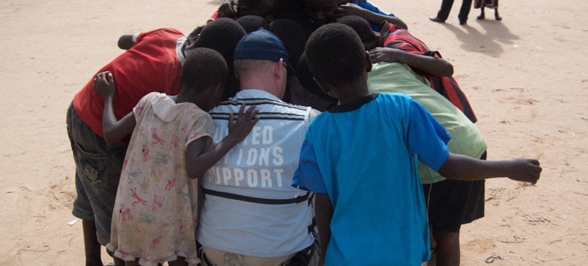 A member of the United Nations Disaster Assessment and Coordination (UNDAC) Team takes a moment to talk with children during the assessment after flooding in the southern part of Malawi in 2015. Credit: UNDAC.