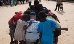 A member of the United Nations Disaster Assessment and Coordination (UNDAC) Team takes a moment to talk with children during the assessment after flooding in the southern part of Malawi in 2015. Credit: UNDAC.