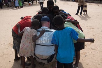 A member of the United Nations Disaster Assessment and Coordination (UNDAC) Team takes a moment to talk with children during the assessment after flooding in the southern part of Malawi in 2015. Credit: UNDAC.