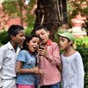 Niños en la Escuela San Columba en Delhi, India, toman fotos con su celular inteligente. 
