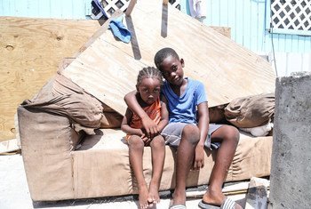 A young boy and his brother sit on a sofa outside their home, which was severely damaged by Hurricane Irma in Grand Turks, Turks and Caicos Islands.