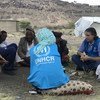 Personal del ACNUR conversa con líderes comunitarios y autoridades locales en el campamento para personas desplazadas de Dharawan afuera de Saná, en Yemen.