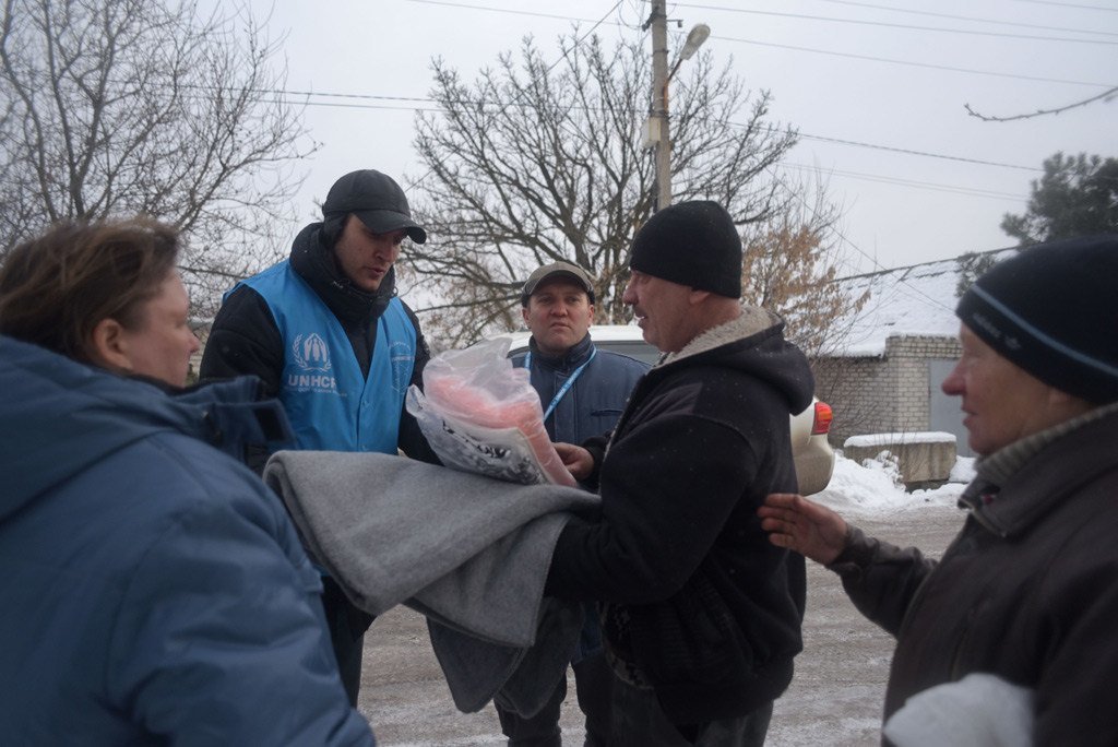 Dinu Lipcanu (centre, wearing baseball cap) Head of UNHCR's Mariupol field office in Ukraine, visits local residents whose houses have been damaged by artillery shelling in Avdiivka, Donetsk.