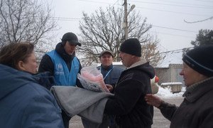 Dinu Lipcanu (en el centro, con una gorra de béisbol), coordinador de la oficina local de ACNUR en Mariupol (Ucrania), visita a los residentes locales cuyas casas han sido dañadas por los bombardeos de artillería en Avdiivka, Donetsk.