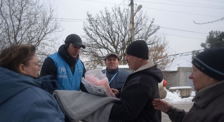 Dinu Lipcanu (centre, wearing baseball cap) Head of UNHCR's Mariupol field office in Ukraine, visits local residents whose houses have been damaged by artillery shelling in Avdiivka, Donetsk.
